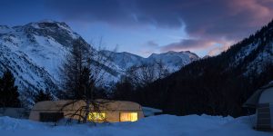 Warmes Licht aus dem Wohnwagen im Abendrot der Engadiner Berggipfel