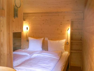 Das frisch bezogene Doppelbett im Holzhaus unterhalb der Galerie