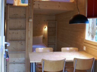 Das Holzhaus beherbergt 4 Personen in einem Doppelbett unten und zwei Einzelbetten auf der Galerie oben