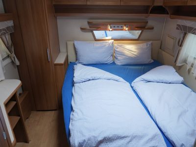 Der Wohnwagen hat ein grosses Doppelbett im vorderen Bereich und ein weiteres Doppelbett