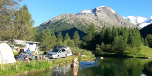 Familie mit Zelt und Auto geniessen die Aktivitäten am Wasser